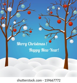 Two trees with Christmas balls on branches in a winter landscape