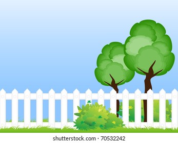 Two trees on the green lawn beyond the wooden fence