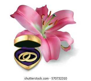 Two wedding rings in a little box in the shape of heart and pink lily. Isolated on the white background.