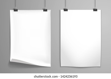 Two white blank realistic posters hangs on the clamps. Mockup for design