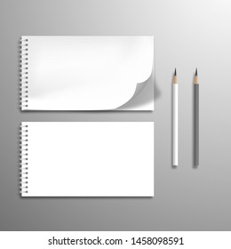 Two white blank spiral notebooks or albums and pencils. At one top sheet is bent. Flat lay mockup with shadow