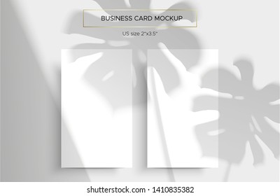 Two White Business cards Mockup. Natural lighting overlays shadows on top. Scene of Tropical Leaf Shadows from the window. A monstera leaf. Photo-realistic vector illustration. Cards 2x3.5 inch.