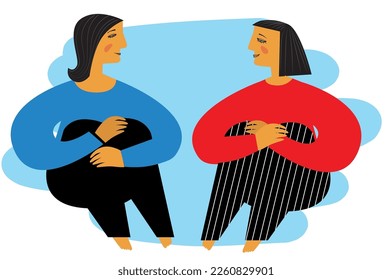 Two women are sitting on the floor and talking
