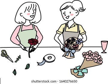 Two women working at a flower shop. Happy women attending flower arrangement workshop, making flower bouquets in a class. Two female florists working together, arranging flower bouquets in studio.