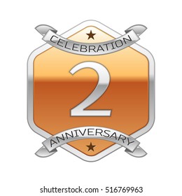 Two years anniversary celebration silver logo with silver ribbon and golden hexagonal ornament on white background.