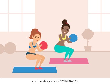two young women exercising with balls in gym