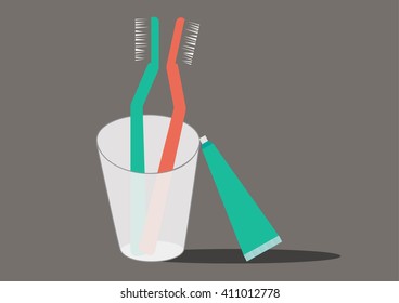 Two-handled toothbrush in a glass , toothpaste 