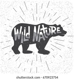 A typography poster with silhouette of bear and hand lettering phrase Wild Nature. Vector illustration. Design for t-shirt, mugs, inspirational poster etc.