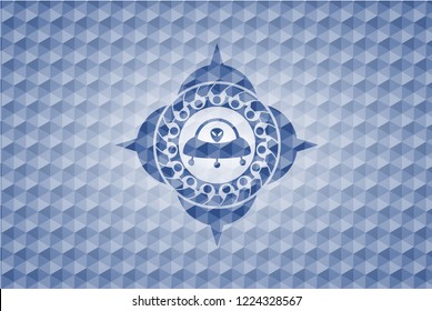 ufo with aline inside icon inside blue emblem with geometric pattern background.