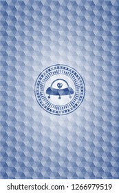 ufo with aline inside icon inside blue emblem with geometric pattern background.