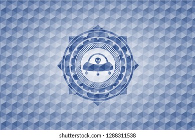ufo with aline inside icon inside blue emblem with geometric pattern background.
