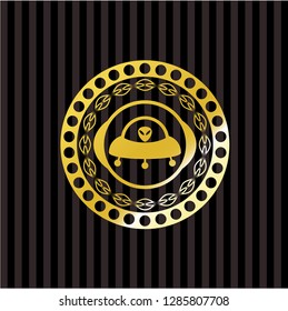 ufo with aline inside icon inside gold emblem