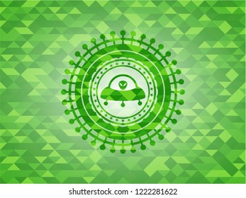 ufo with aline inside icon inside green mosaic emblem