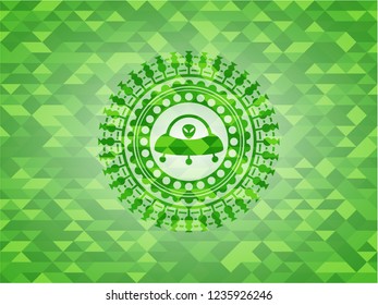 ufo with aline inside icon inside green emblem with mosaic background
