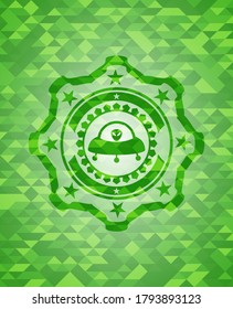 ufo with aline inside icon inside green mosaic emblem. 