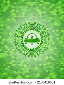 ufo with aline inside icon inside green emblem. Mosaic background. 