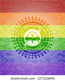 ufo with aline inside icon on mosaic background with the colors of the LGBT flag