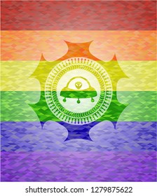 ufo with aline inside icon on mosaic background with the colors of the LGBT flag