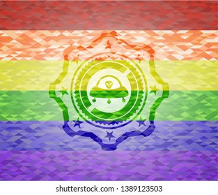 ufo with aline inside icon on mosaic background with the colors of the LGBT flag