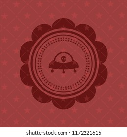 ufo with aline inside icon inside red emblem