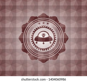 ufo with aline inside icon inside red seamless emblem or badge with abstract geometric polygonal pattern background.