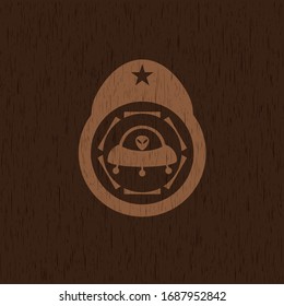 ufo with aline inside icon inside retro style wooden emblem