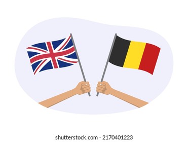 UK and Belgium flags. Belgian and British national symbols. Hand holding waving flag. Vector illustration.