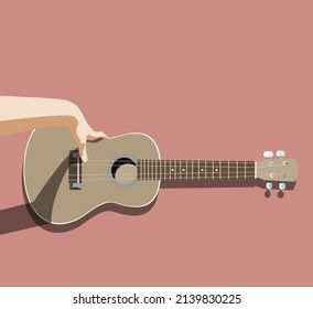 Ukulele front view with a hand trying to play it, isolated on pink background