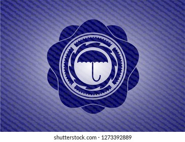 umbrella icon inside badge with denim texture