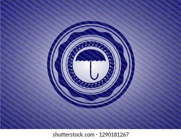 umbrella icon inside badge with denim background