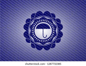 umbrella icon inside badge with jean texture