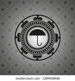 umbrella icon inside dark badge or emblem
