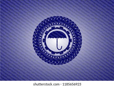 umbrella icon inside emblem with jean texture