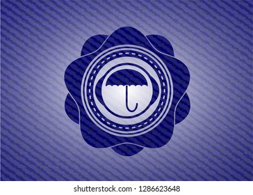 umbrella icon inside emblem with jean high quality background