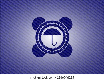 umbrella icon inside emblem with jean background