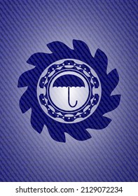 icono del paraguas dentro del emblema con fondo jean. 
