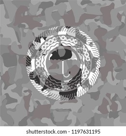 umbrella icon inside grey camo emblem