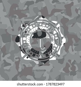 umbrella icon inside grey camo emblem. 
