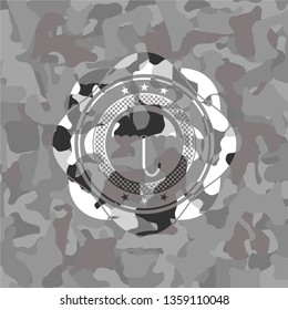 umbrella icon inside grey camouflaged emblem