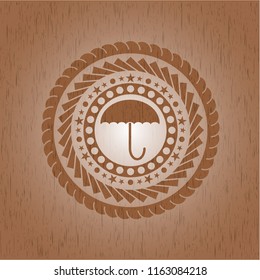 umbrella icon inside wood badge or emblem
