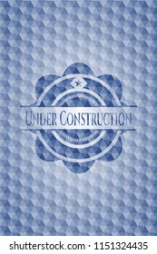 Under Construction blue emblem with geometric background.