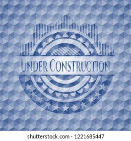 Under Construction blue emblem with geometric background.