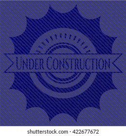 Under Construction emblem with denim high quality background