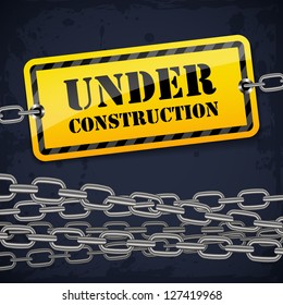 Under construction sign with chain on grunge background