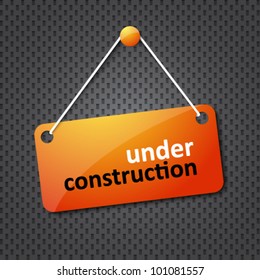 under construction sign hung on a textured background