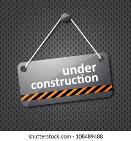 under construction sign hung on a textured background
