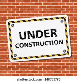 Under construction sign on brick wall, vector eps10 illustration