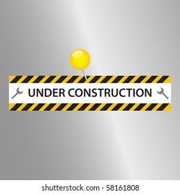Under Construction sign pinned to a metallic surface.