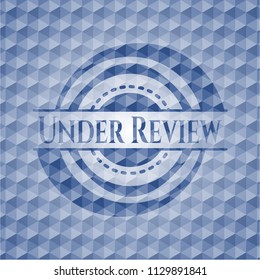 Under Review blue badge with geometric pattern background.