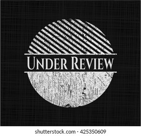 Under Review chalkboard emblem written on a blackboard